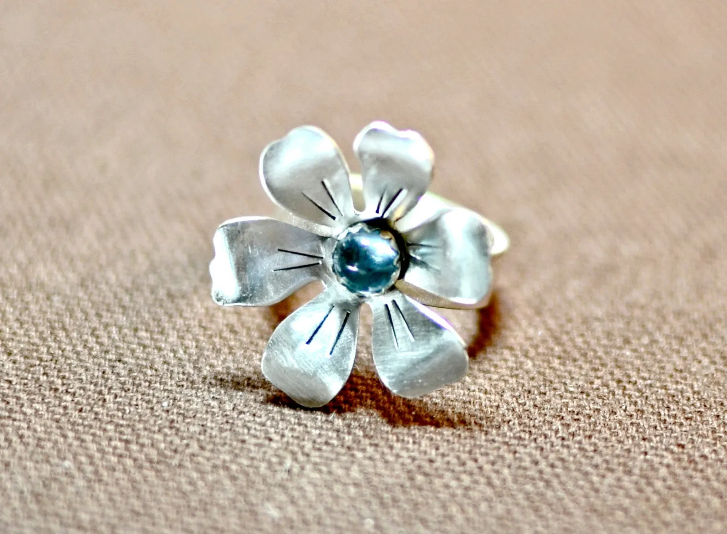 Flower shaped sterling silver ring with blue topaz