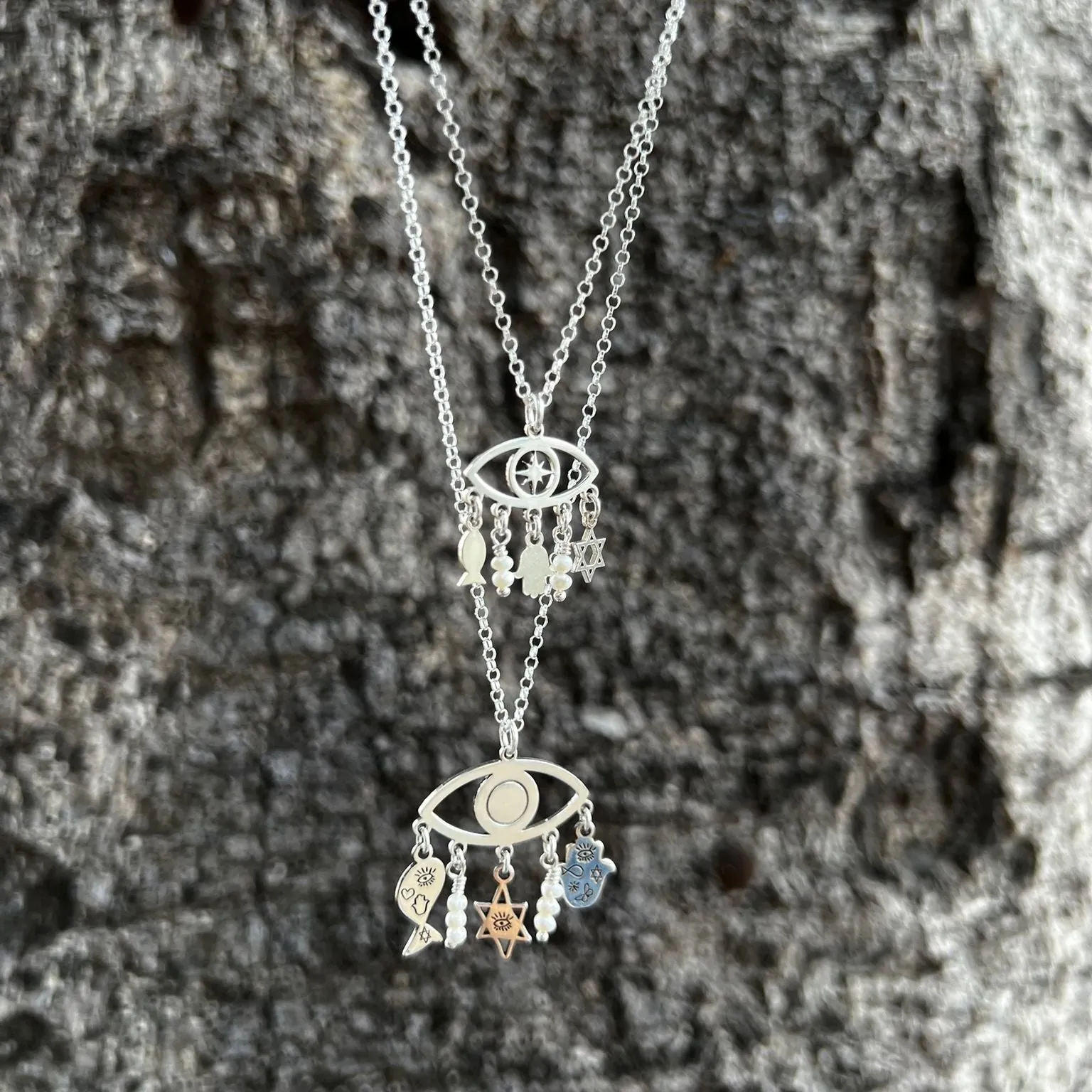 Sterling Silver Charms of Israel hanging on the protection symbol eye. Fish, Star of David, Hamsa.